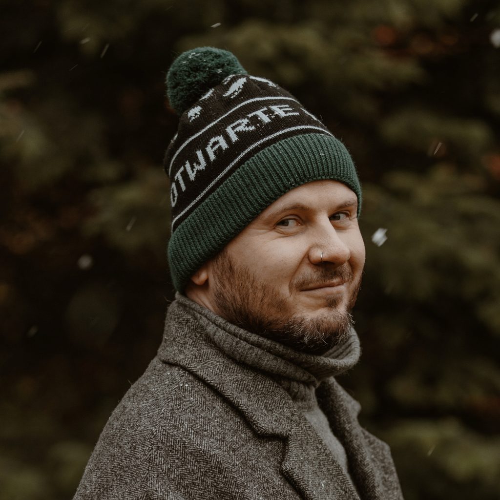 Zielona czapka zimowa z napisem "Otwarte Klatki"